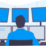 A man with a blue collard shirt and black hair looking into six monitors at his work desk.