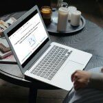 Laptop on a table displaying a Froala WYSIWYG HTML editor.